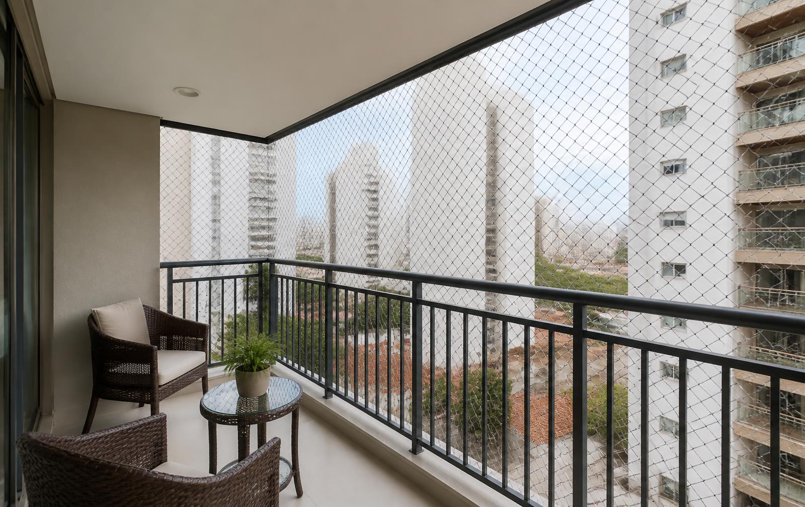 Sacada de apartamento com rede de proteção instalada fechando todo o vão, com vista para a cidade